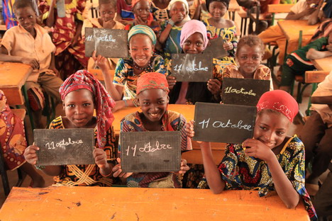 Plan protestiert mit Beleuchtungsaktion gegen die Benachteiligung von Mädchen in Entwicklungsländern - Eine Schulklasse aus Niger freut sich auf den Welt-Mädchentag am 11. Oktober; Foto: Plan / Shona Hamilton
